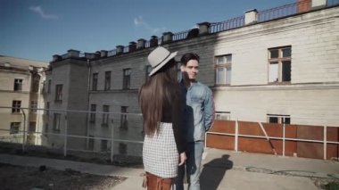 Şık bir adam ve kız sokakta kameranın önünde poz veriyorlar..