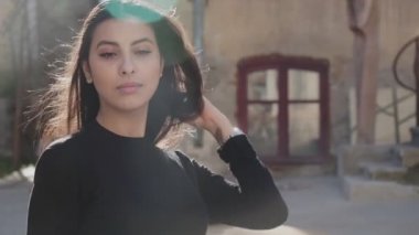 Kapalı alanda uzun siyah saçlı bir kızın portresi.