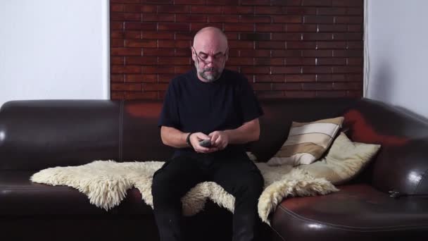 Homem Barbudo Muda Canais Enquanto Sentado Sofá — Vídeo de Stock