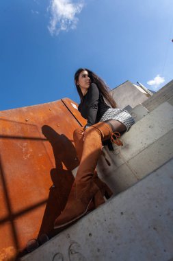 Binanın basamaklarında oturan şık kız modeli.