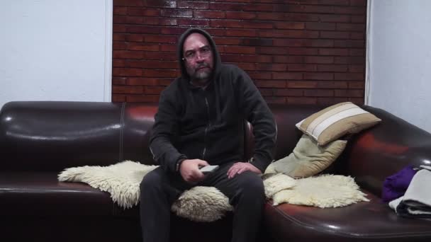 Homem Barbudo Muda Canais Enquanto Sentado Sofá — Vídeo de Stock