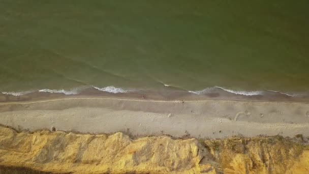 ビーチと海の空中トップビュー 海の中の柔らかい波と小石を岸に午前中は水の色が美しく輝いていました 4Kビデオ — ストック動画