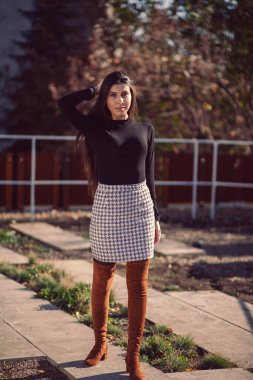 Şehir parkında poz veren genç ve modaya uygun bir kızın moda kadın portresi..