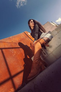 Binanın basamaklarında oturan şık kız modeli.