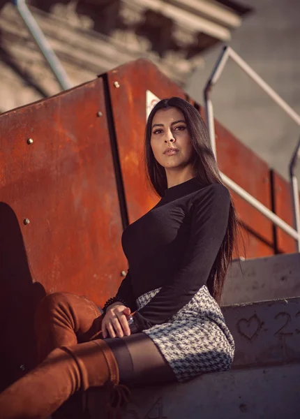Binanın basamaklarında oturan şık kız modeli.