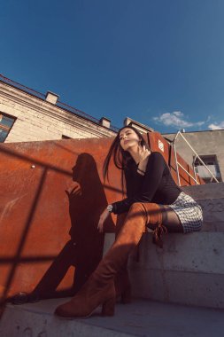 Binanın basamaklarında oturan şık kız modeli.