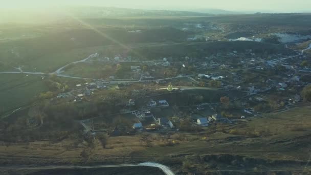 Uma pequena aldeia no campo com pouca igreja no centro. Vista aérea. 4K . — Vídeo de Stock