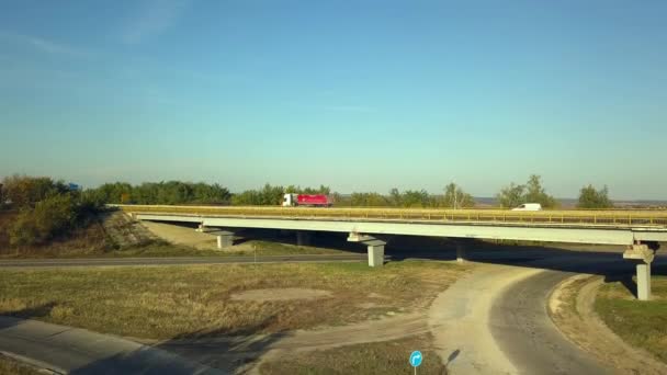 AERIAL Widok Latające nad Oszałamiający upadek natury i drogi Biegnącej przez malowniczą okolicę. Droga w jesiennej scenerii Zdjęcia lotnicze. Samochodowa droga prowadząca przez kolorowy krajobraz jesienią. — Wideo stockowe