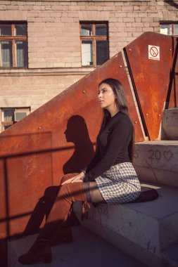 Binanın basamaklarında oturan şık kız modeli.