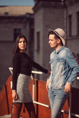 Şık bir adam ve kız sokakta kameranın önünde poz veriyorlar..