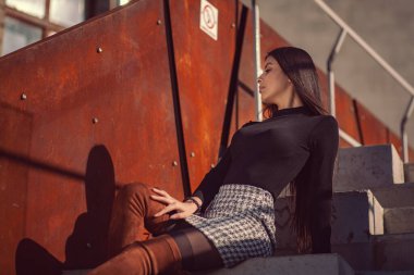 Binanın basamaklarında oturan şık kız modeli.