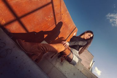 Binanın basamaklarında oturan şık kız modeli.