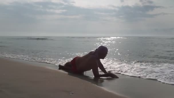 Σιλουέτα Ενός Άντρα Κείτεται Δίπλα Στη Θάλασσα Την Αυγή — Αρχείο Βίντεο