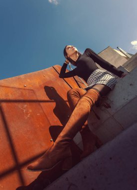 Binanın basamaklarında oturan şık kız modeli.