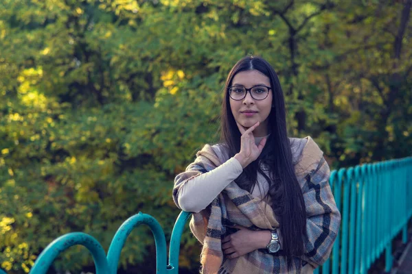 Close up de mulher feliz emocionalmente morena com cabelos longos e óculos. Modelo bonito com maquiagem perfeita após o salão, posando no parque. Conceito de moda e beleza . — Fotografia de Stock