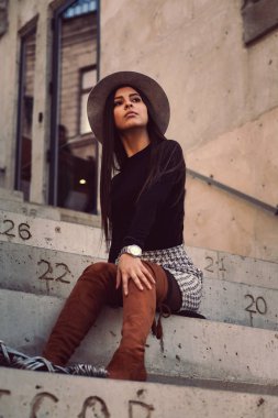 Binanın basamaklarında oturan şık kız modeli.