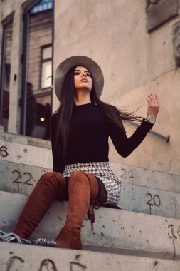 Binanın basamaklarında oturan şık kız modeli.