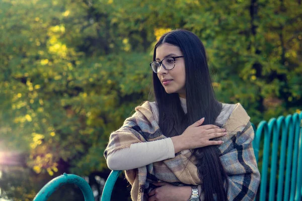 Close up of happy emotionally brunette woman with long hair and glasses. Beautiful model with perfect makeup after salon, posing in park. Concept of fashion and beauty. — Stock Photo, Image