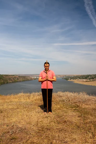 Bir adam, doğada bir sırıkla iyileştirici jimnastik yapar. Sağlıklı yaşam tarzı. — Stok fotoğraf