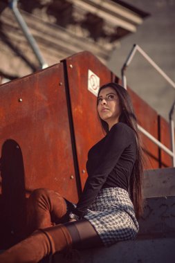 Binanın basamaklarında oturan şık kız modeli.