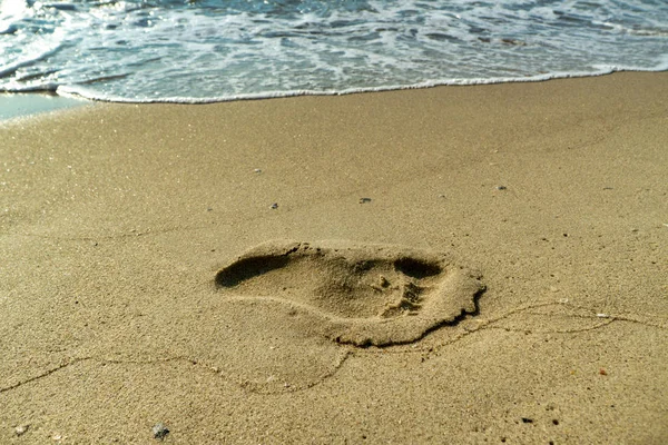 Huellas de una persona en la arena mojada de una playa — Foto de Stock