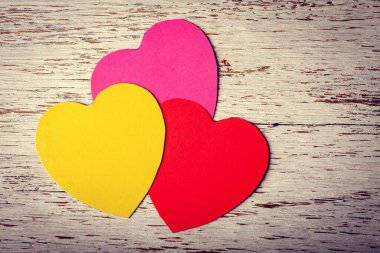 Ahşap arka planda renkli kağıt kalpler. Tatillerde. Sevgililer Günü.