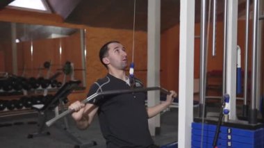 Spor salonunda vücut geliştiren bir adam, bir barla çalışıyor, trisepsleri geliştiriyor, büyük göğüs kası ve ön deltoid kası var. Aşk sporlarından anlayan, spor salonuna giden, sağlıklı beslenen...