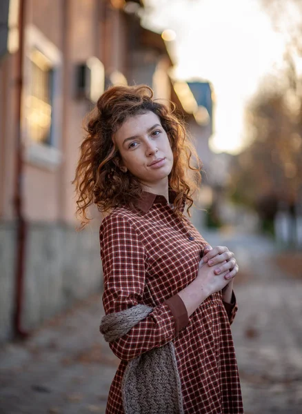 Sonhando jovem mulher com cabelo encaracolado gengibre vermelho espetacular olhando para câmera posando ao ar livre no centro da rua. Retrato feminino . — Fotografia de Stock