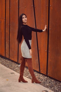 Modern dünyanın arka planında poz veren güzel bir kız modeli.