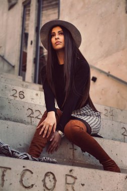 Binanın basamaklarında oturan şık kız modeli.