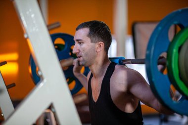 Man in Gym lifts the barbell, muscle training with weights, powerlifting.