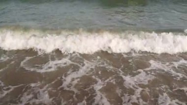Ashore A Sandy Beach 'i yıkayan Deniz Dalgalarının Kapanışı. Yavaş çekim.
