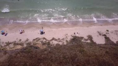 Plaj ve deniz havası manzarası. Denizde yumuşak dalgalar ve çakıl taşları. Suyun rengi sabahları çok güzel parlıyor. 4k video