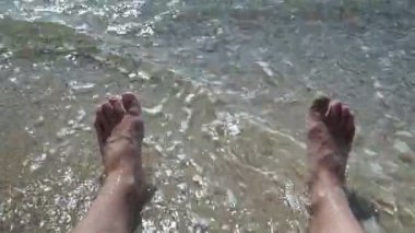 Erkek bacakları. Denizde erkek ayağı. Deniz kıyısında erkek ayakları.
