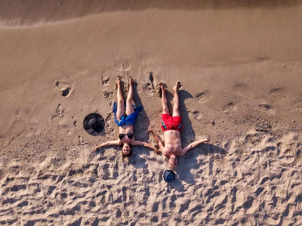 Drone photo. The couple lies on the beach. Top view — Stock Photo, Image