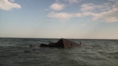 Denizde bir gemi battı. Vuruldu. Batık bir gemiyle deniz manzarası. Eski tekne denize düşer.