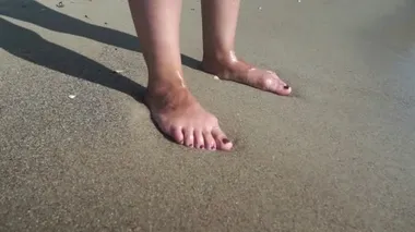 Yanık tenli kadın ayakları üzerinde yıkama dalgalar deniz. Güzel ve genç birbayan rahatlatıcı yaz tatili sırasında kıyısında. Güneşli bir günde sahilde yatan kız bacaklar. Yavaş hareket kapatmak