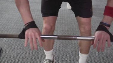 Man in Gym lifts the barbell, muscle training with weights, powerlifting.