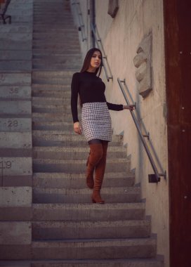 Kız model binanın merdivenlerinden aşağı iniyor.