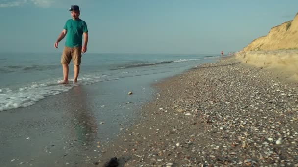 在日出时分 一个人平静地沿着荒芜的海滩走着 — 图库视频影像