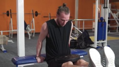 Sporcu adam spor salonunda ağırlık kaldırıyor. Spor, sağlık, yaşam tarzı.