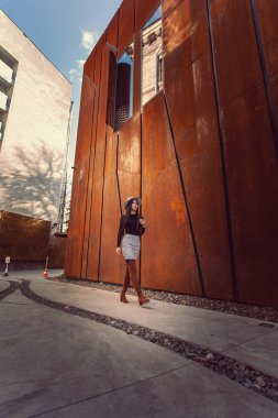 Modern binanın arka planında poz veren güzel bir kız modeli.