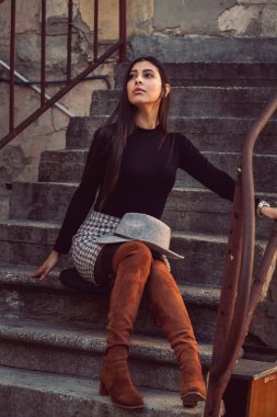 Binanın basamaklarında oturan şık kız modeli.