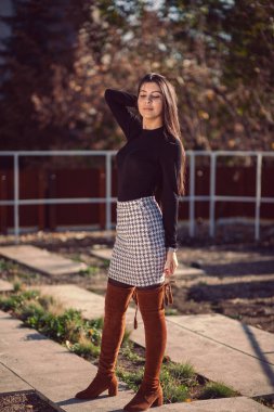 Şehir parkında poz veren genç ve modaya uygun bir kızın moda kadın portresi..