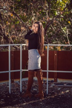 Şehir parkında poz veren genç ve modaya uygun bir kızın moda kadın portresi..