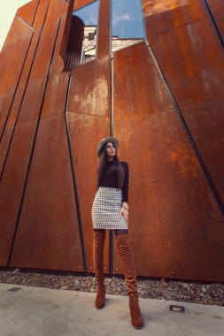 Modern binanın arka planında poz veren güzel bir kız modeli.