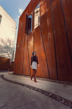 Modern binanın arka planında poz veren güzel bir kız modeli.