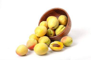 Tahta kasede taze kayısılar, beyaz arka planda izole edilmiş..