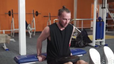 Sporcu adam spor salonunda ağırlık kaldırıyor. Spor, sağlık, yaşam tarzı.