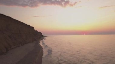 Gündoğumu gökyüzü arkaplanının hava görüntüsü. Denizin üzerinde sabah gökyüzü bulutları olan havadan dramatik altın bir gün doğumu. Güneşin doğuşunda çarpıcı gökyüzü bulutları. Hava görüntüsü. 4k.